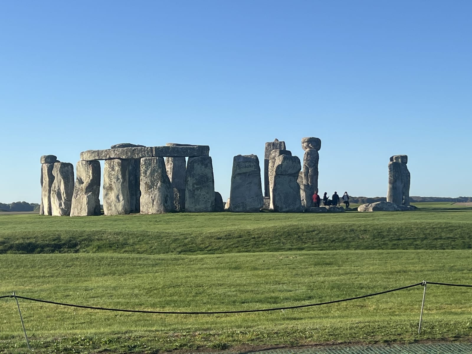 Visitors standing inside the Stonehenge stone circle on a paid tour