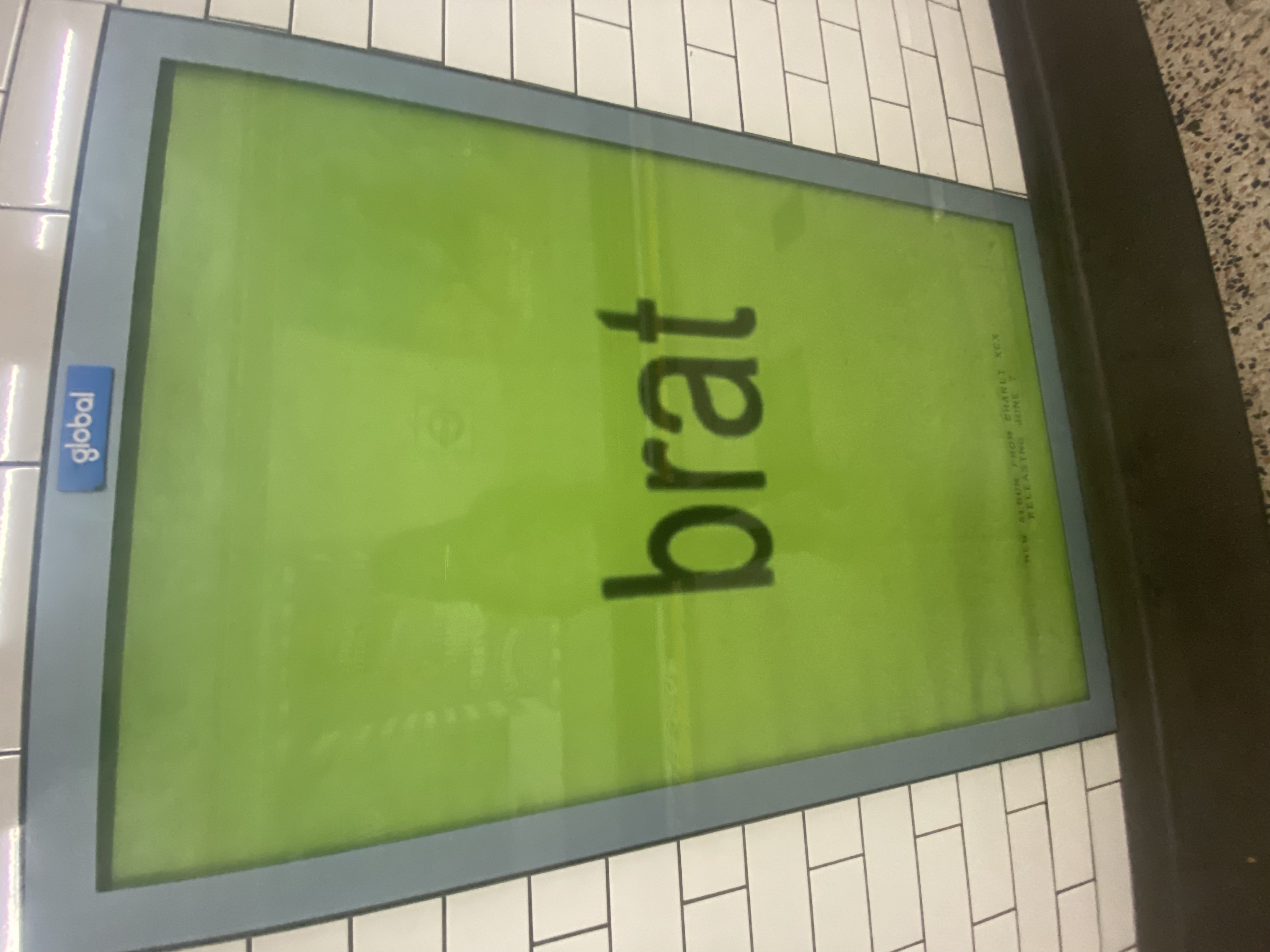 London Underground poster promoting Charli XCX&rsquo;s latest album, &ldquo;brat&rdquo;. &ldquo;brat&rdquo; is shown in lower case in the centre of the poster with a lime green background.