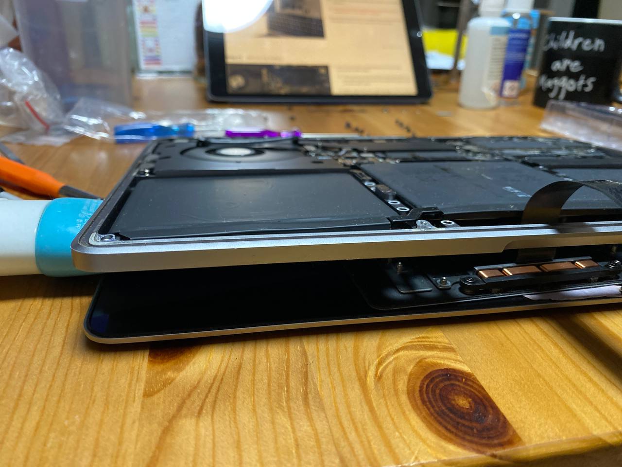 Macbook with internals exposed. The Macbook is lying with the logic board side-up.