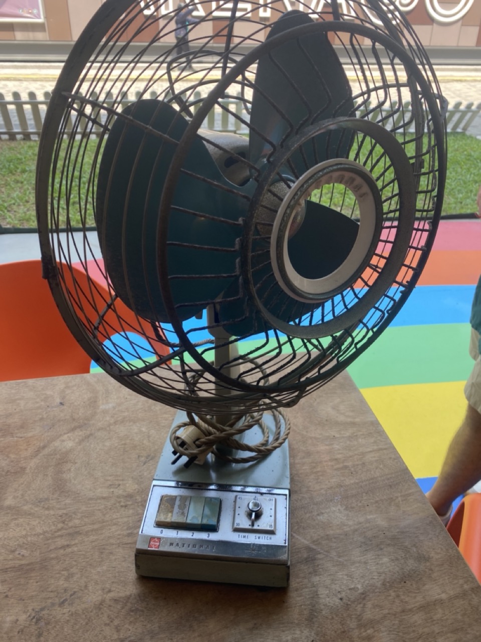 Fan with blue blades on a table.