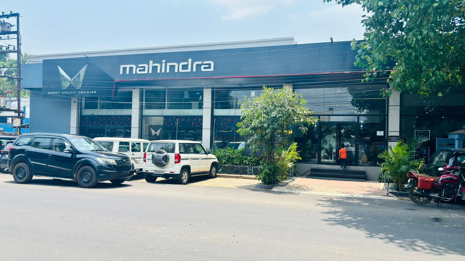 Outdoor view of large Mahindra dealership with vehicle display lot