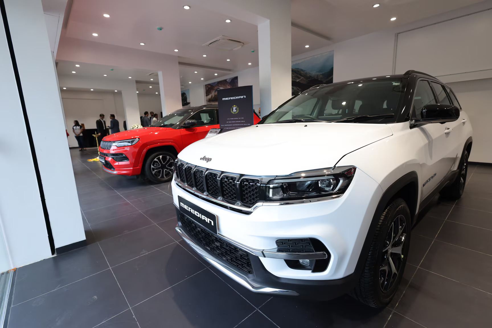 Inside premium Jeep showroom with iconic 4x4 SUVs on polished floor