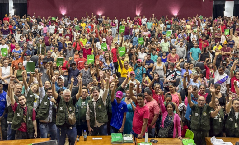 Famílias assentadas no Acre celebram com braços levantados a conquista de Contratos de Concessão de Uso (CCU) e títulos definitivos de propriedade. A ação do Incra garante a segurança jurídica necessária para que os agricultores familiares acessem novos financiamentos e desenvolvam sua produção | Foto: Incra/AC