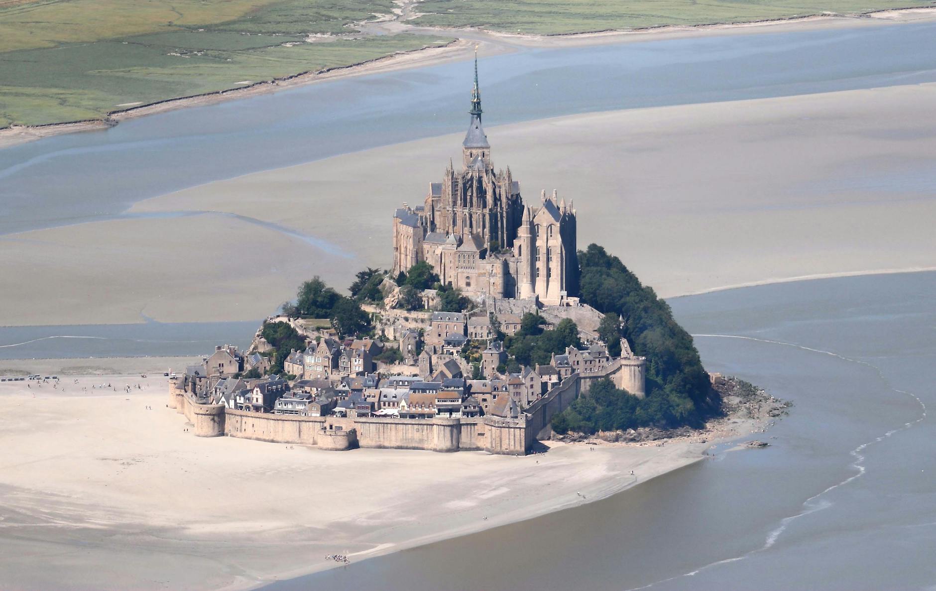 Stunning aerial shot of the iconic Mont Saint-Michel surrounded by tidal waters in Normandy, France.