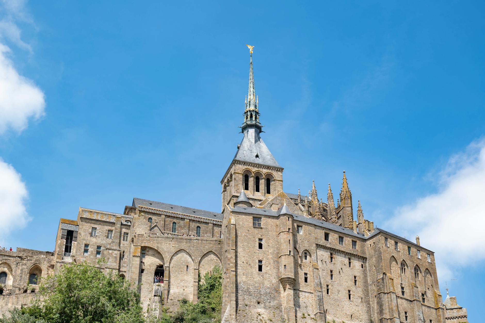 Majestic view of Mont Saint-Michel, a historic abbey in Normandy, France, under a clear blue sky.