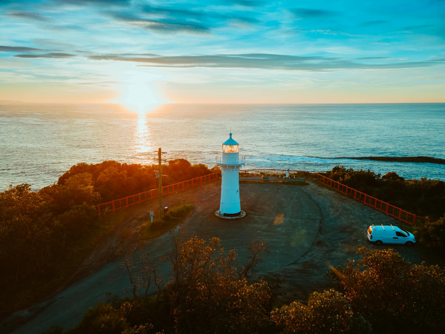 A stunning sunset over Ulladulla lighthouse, NSW, Australia, with vivid colors and coastal scenery.
