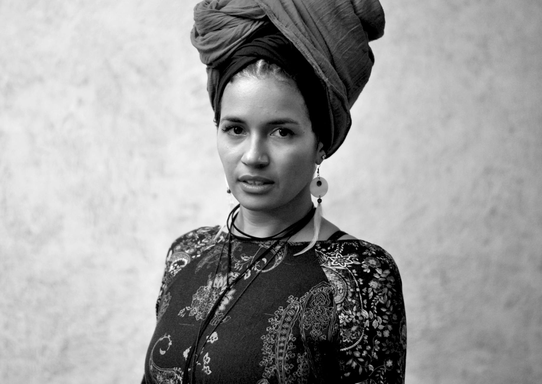 Portrait of a woman with a turban and floral dress, showcasing elegant fashion and cultural style.