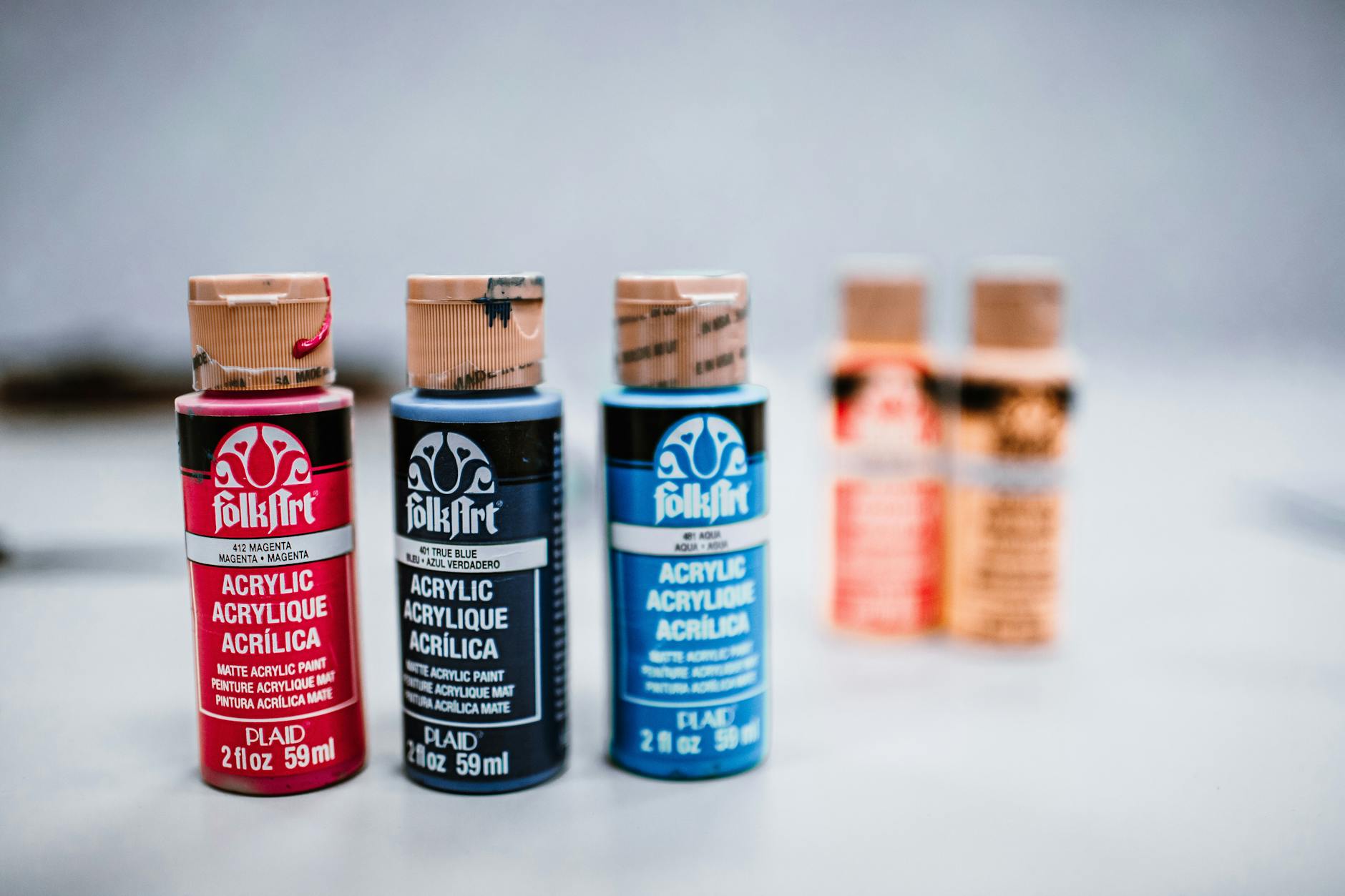 Colorful acrylic paint bottles displayed on a surface, perfect for creative art projects.