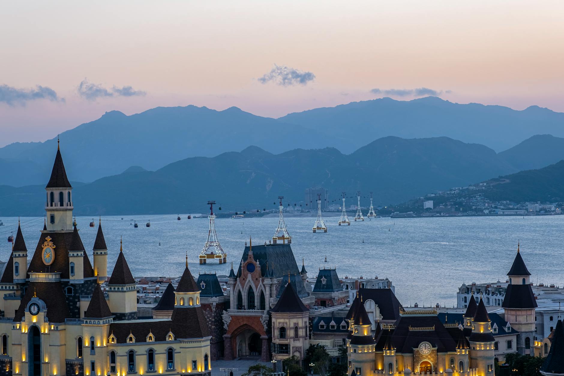 Vinwonders park with glowing towers located on coastal area near sea against mountain ridge in Hha Trang city in evening time