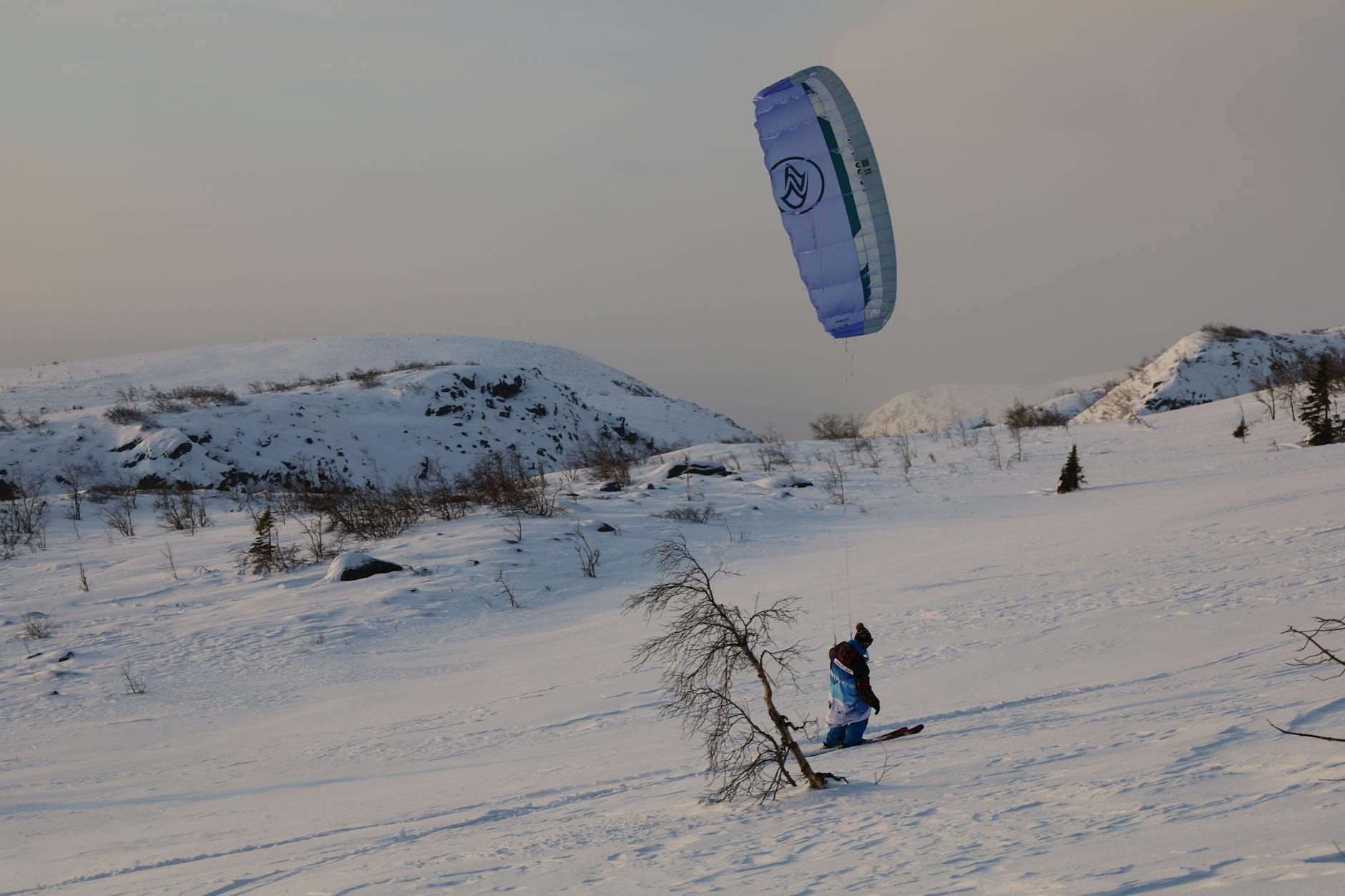 Kiteboarding on snow in Kirovsk, Russia, showcasing winter sports excitement and snowy landscapes.