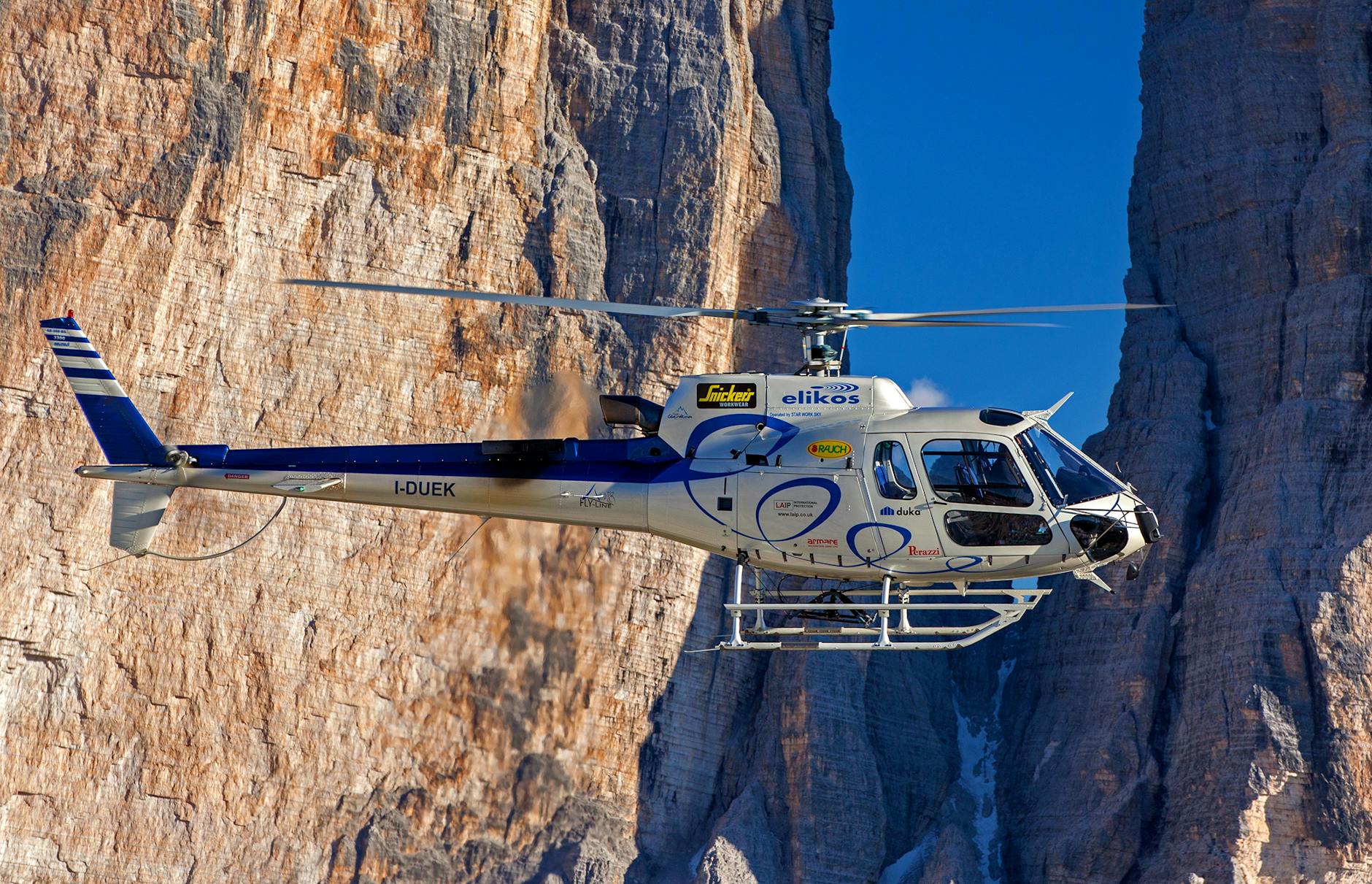 A helicopter navigating through the stunning landscapes of the Dolomites in Auronzo di Cadore, Italy.