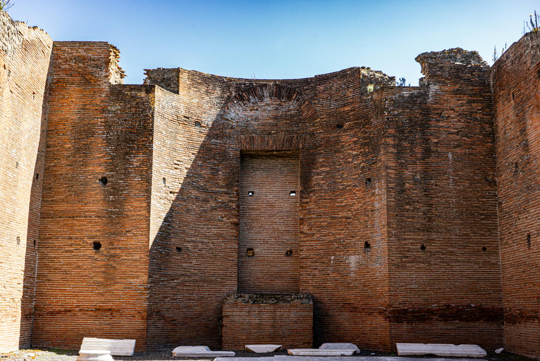 View of historic brick wall ruins in Pompeii, Italy on a sunny day.