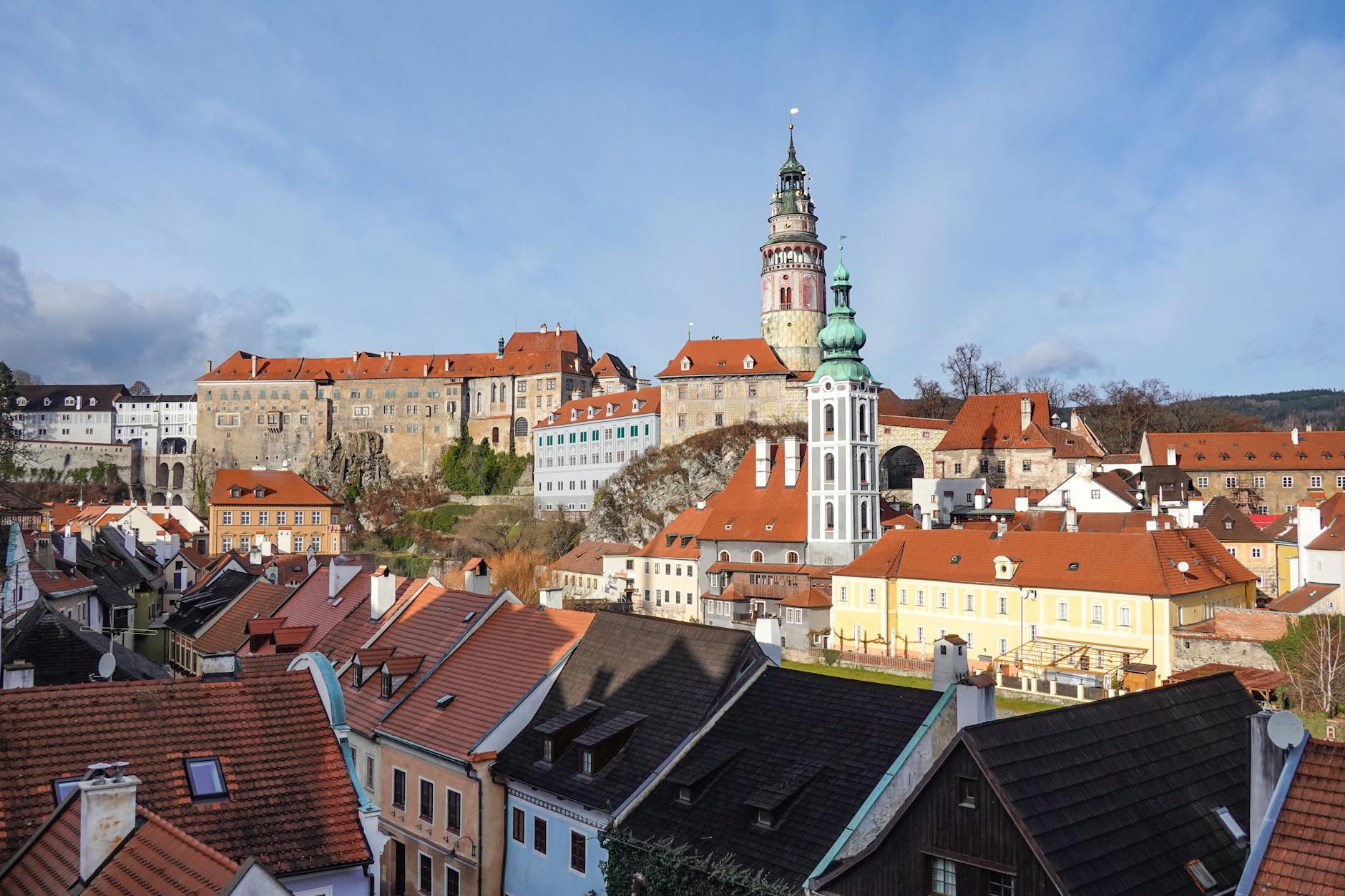 A picturesque view of Český Krumlov Castle and the historic old town under a clear blue sky.