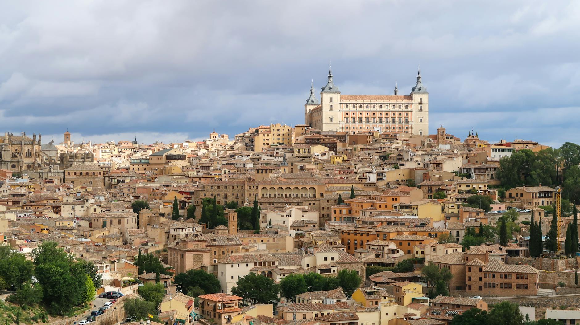 Stunning aerial view of Toledo, Spain featuring the historic Alcazar amid a vibrant cityscape.