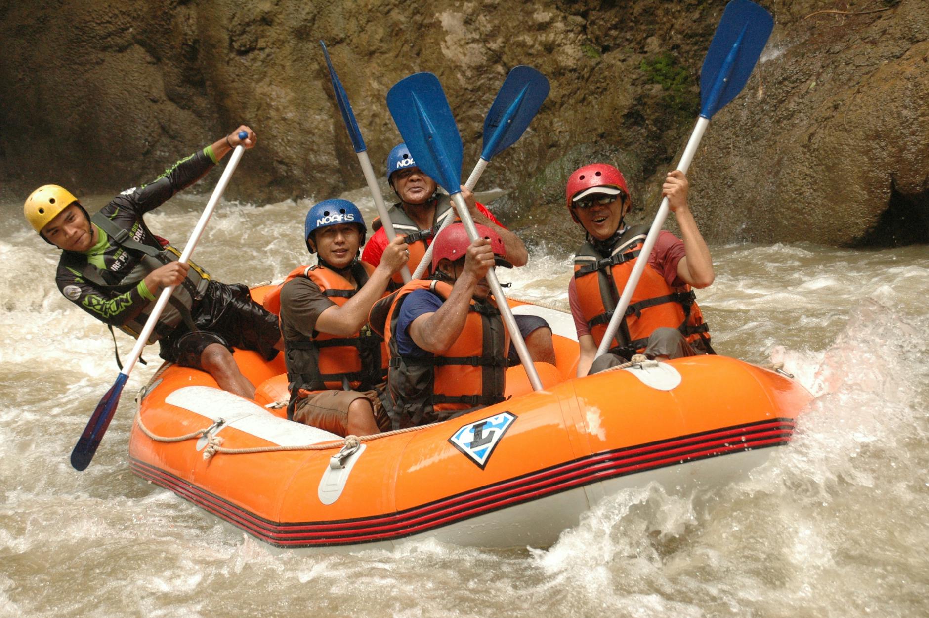 Group of adults enjoying an exhilarating whitewater rafting adventure in a turbulent river.