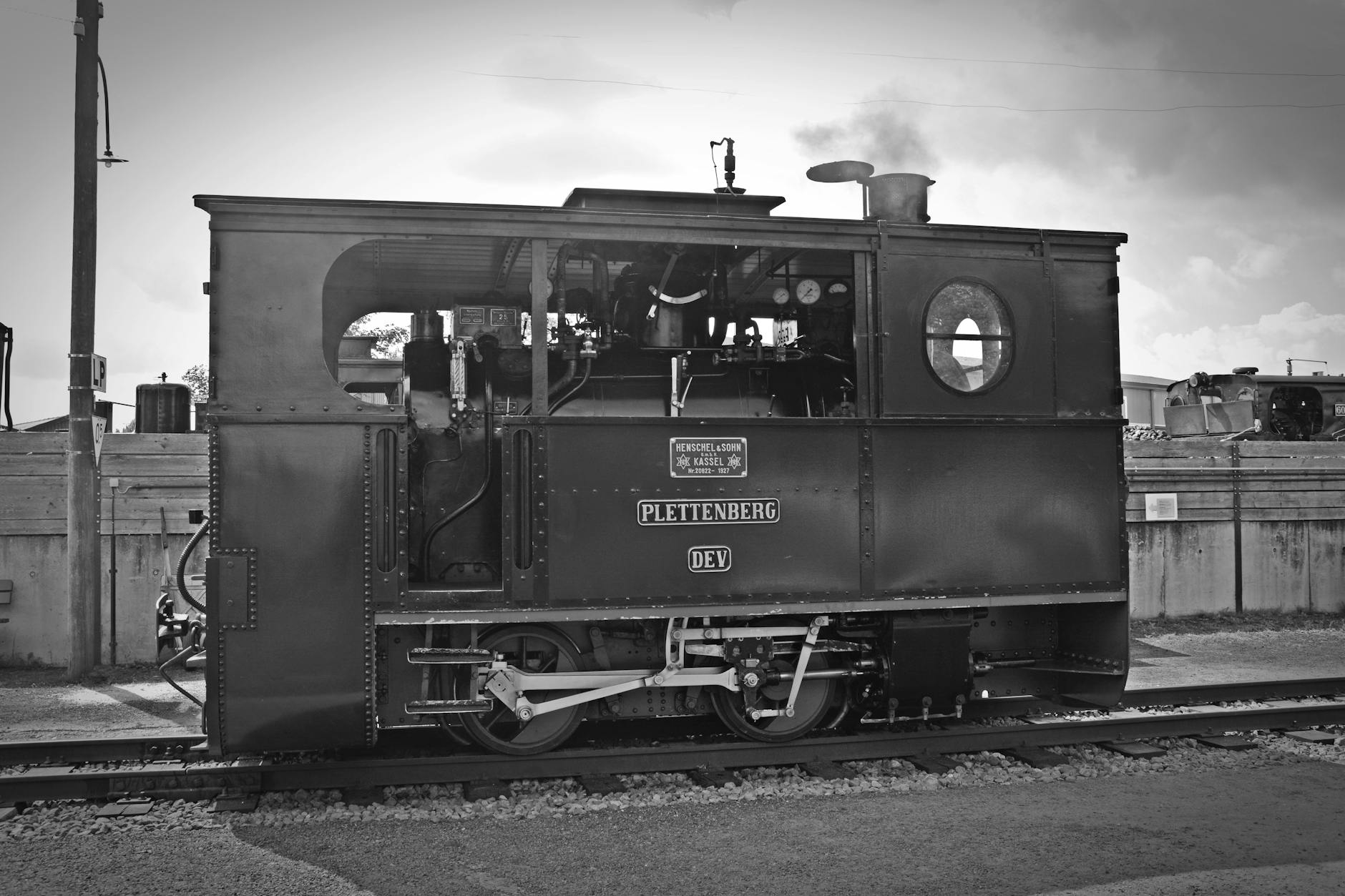 Nostalgic black and white photo of a vintage steam locomotive on the railway track.
