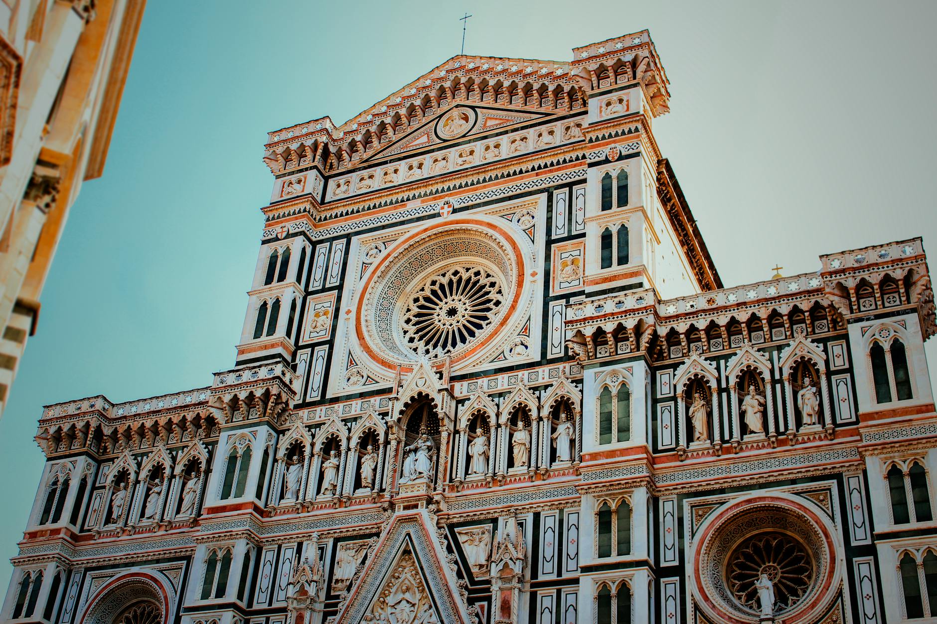 Intricate details of the Florence Cathedral facade showcasing Gothic architecture in bright daylight.