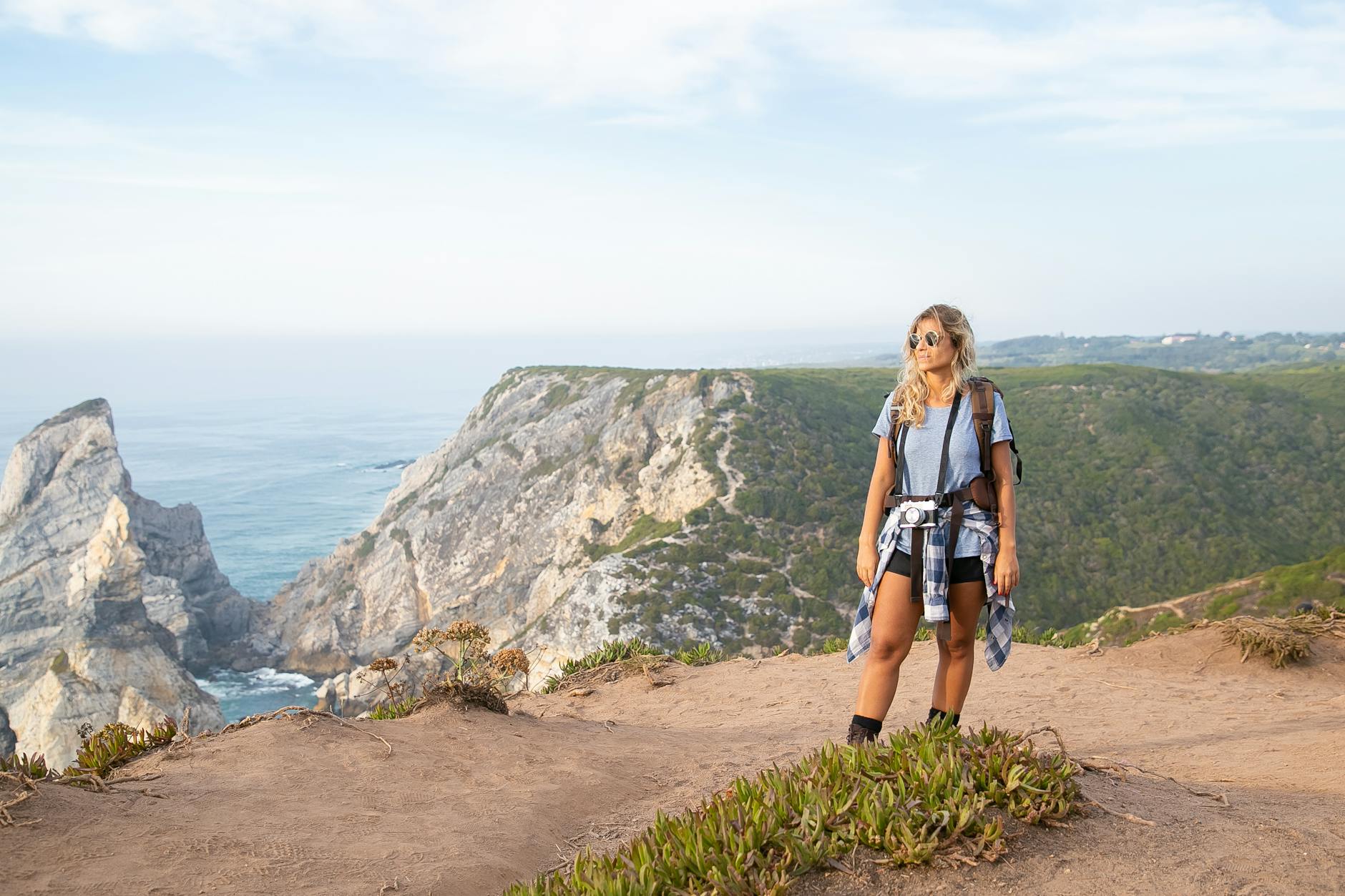 Woman on a hiking adventure at the cliffs of Portugal, capturing stunning coastal views.