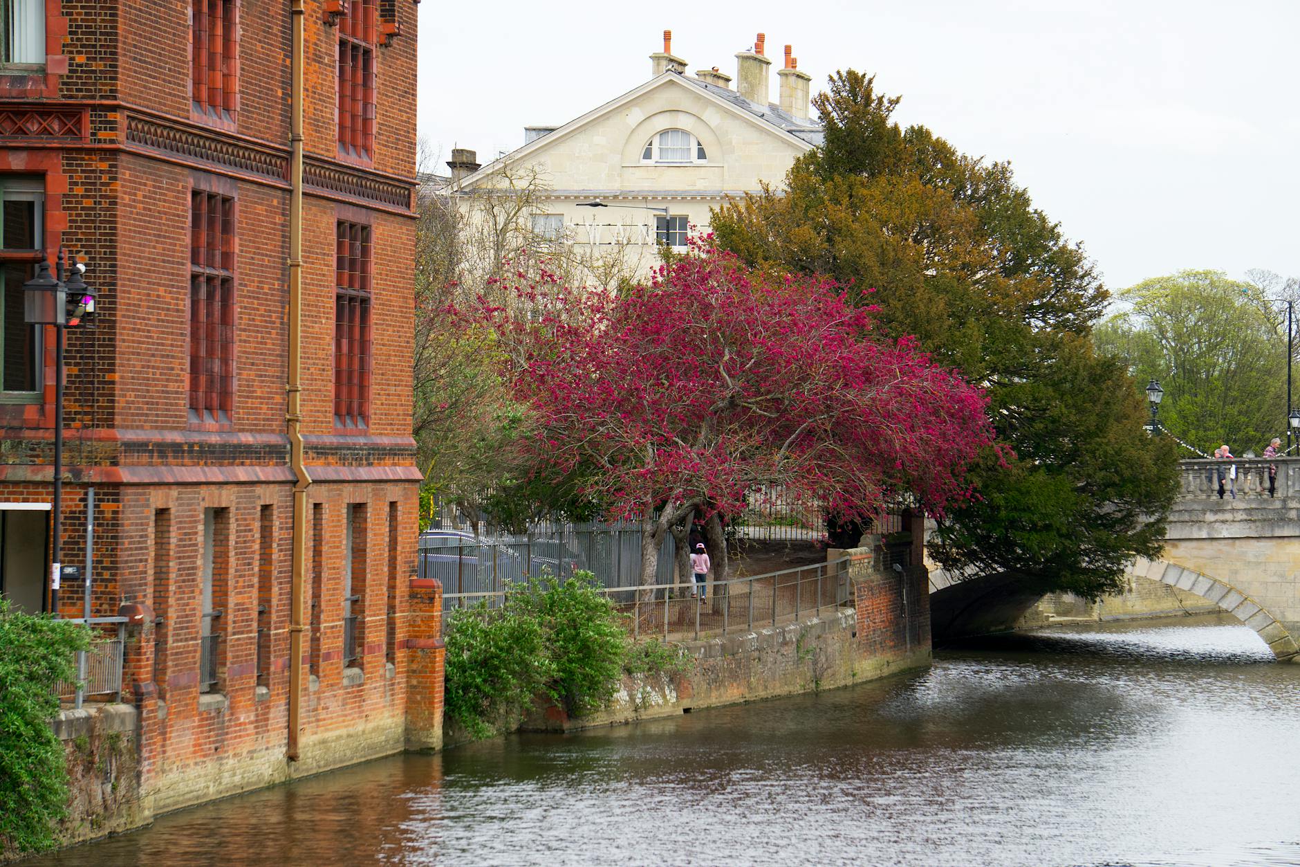 Brick building and bridge by a serene riverside in Bedford, England.