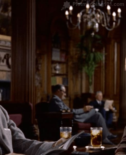 Two men under the chandelier in the background