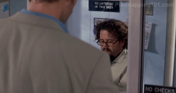 Leonard walks up to the front desk of the hotel, with Bert behind it.