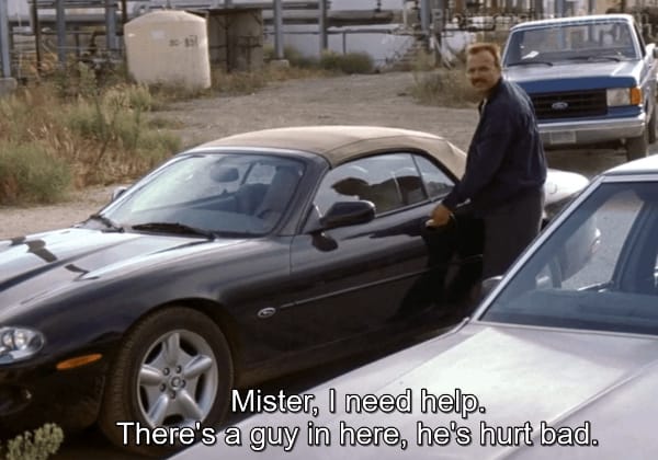 "Mister, I need help.  There's a guy in here, he's hurt bad," Leonard shouts to Teddy, who is trying the door of the convertible.