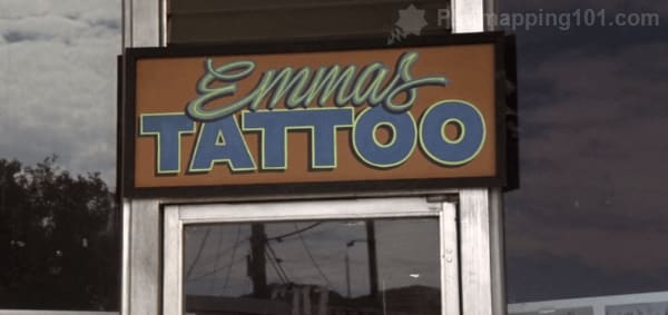 A shop sign over a doorway says Emma's Tattoo.