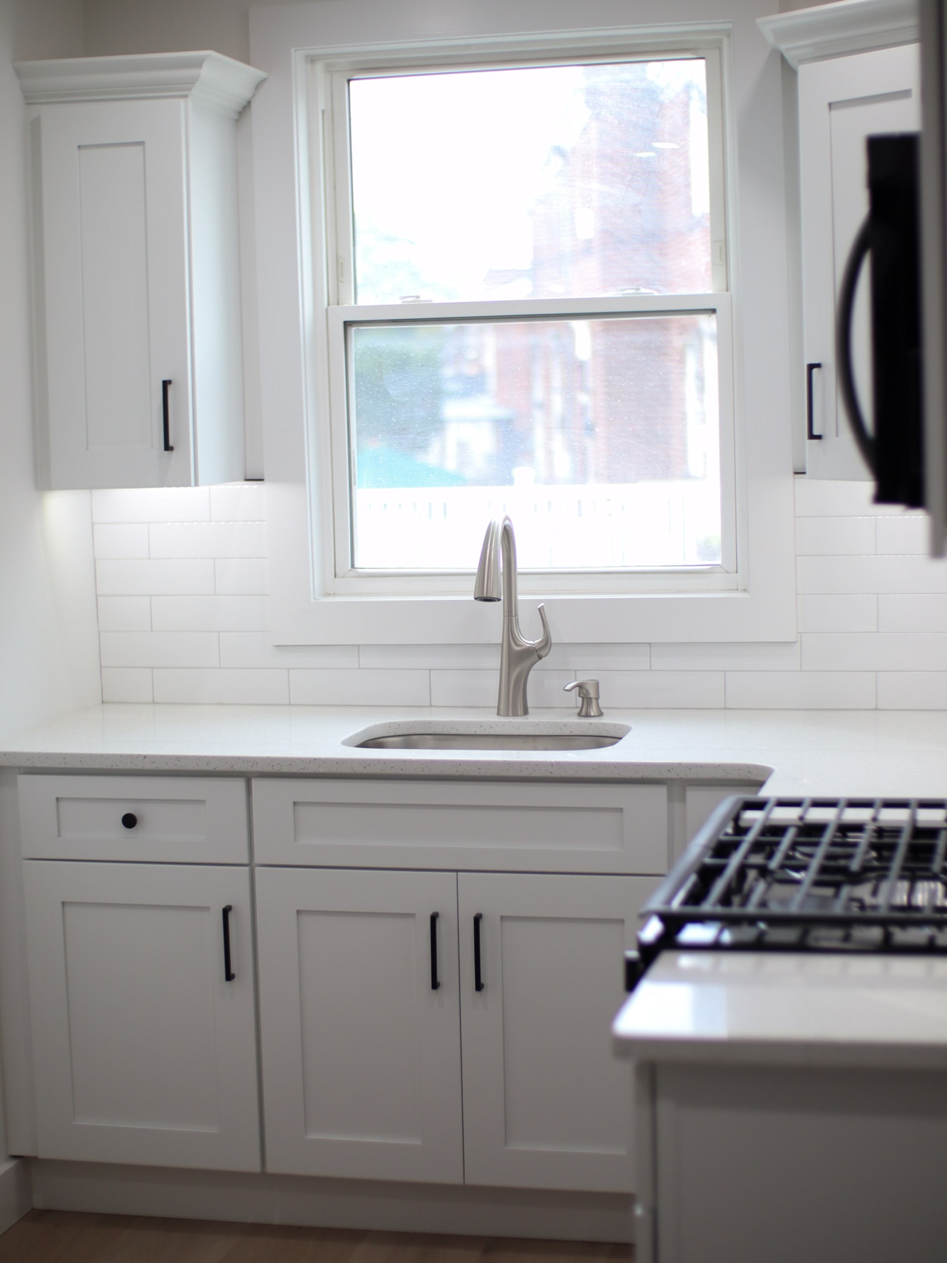 Finished kitchen with sink, gas range, and quartz counters