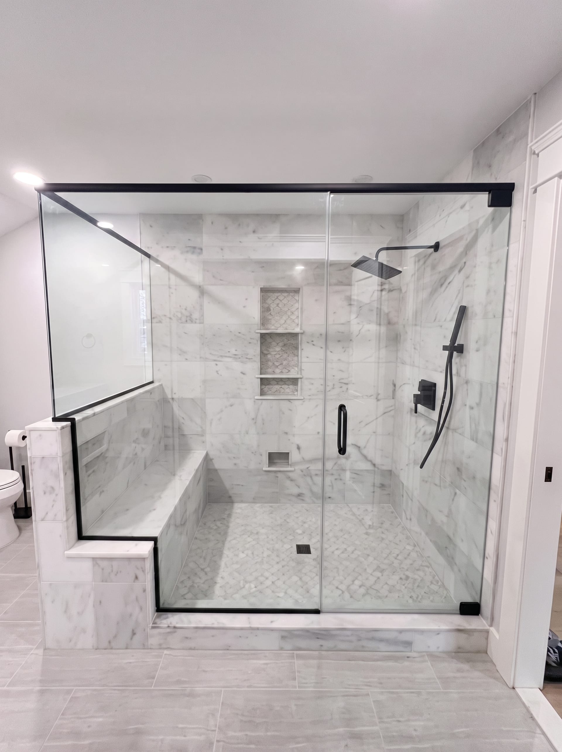 Glass-enclosed shower with marble bench, AZ Home Remodeling