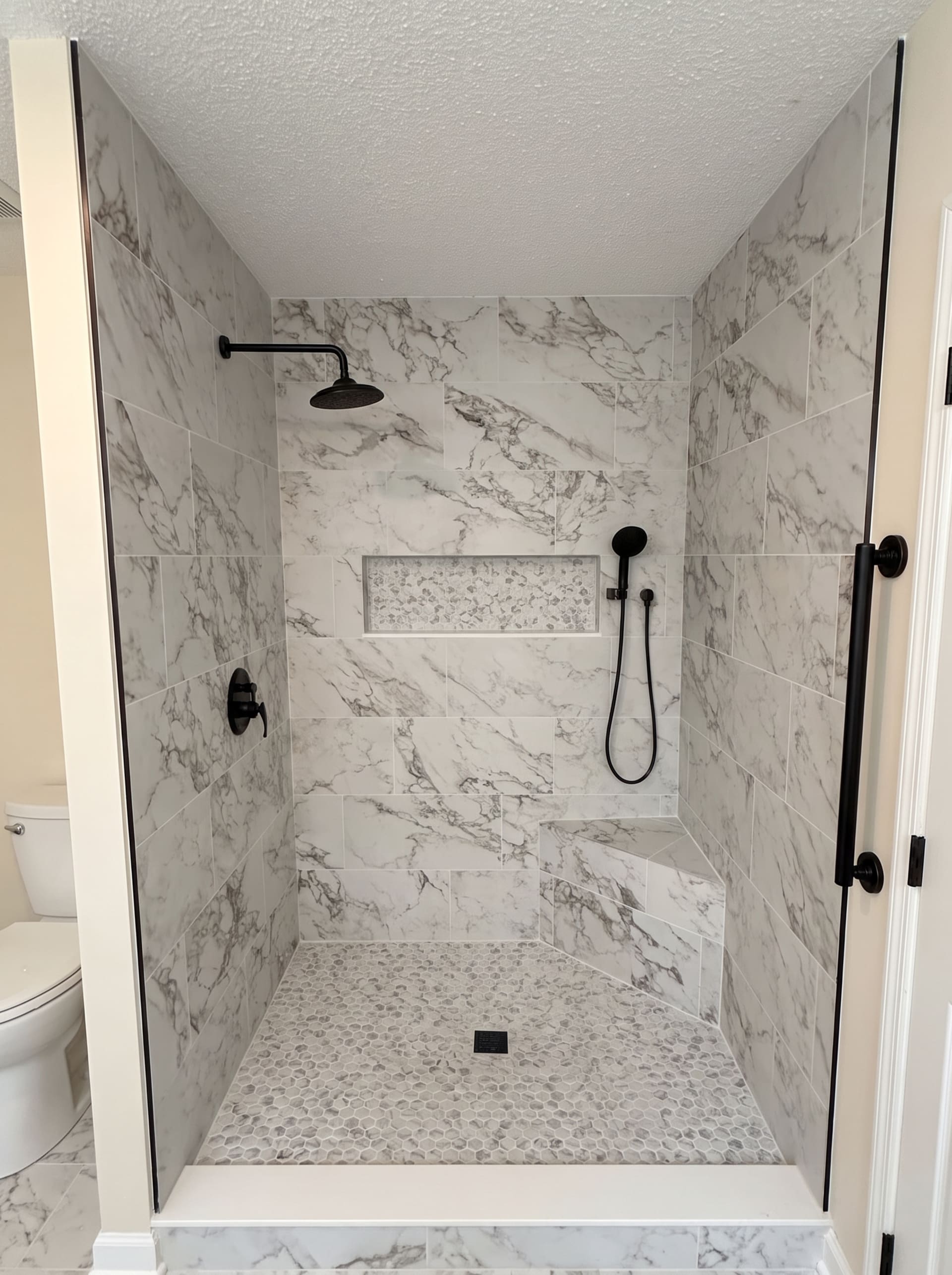 Marble-tiled shower with built-in bench, AZ Home Remodeling