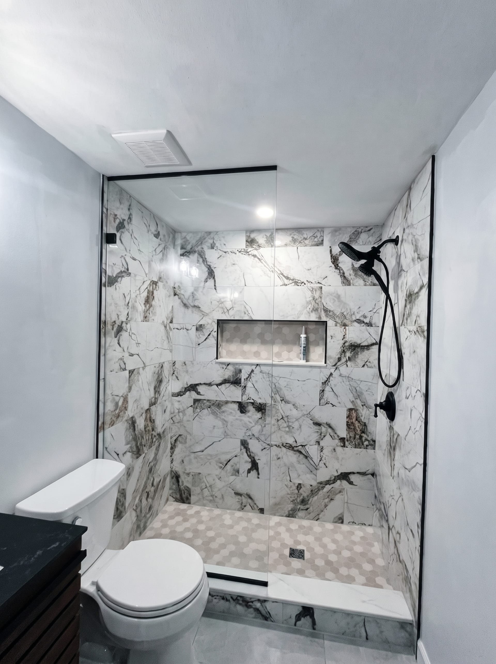 Marble-tiled shower with a built-in niche, AZ Home Remodeling