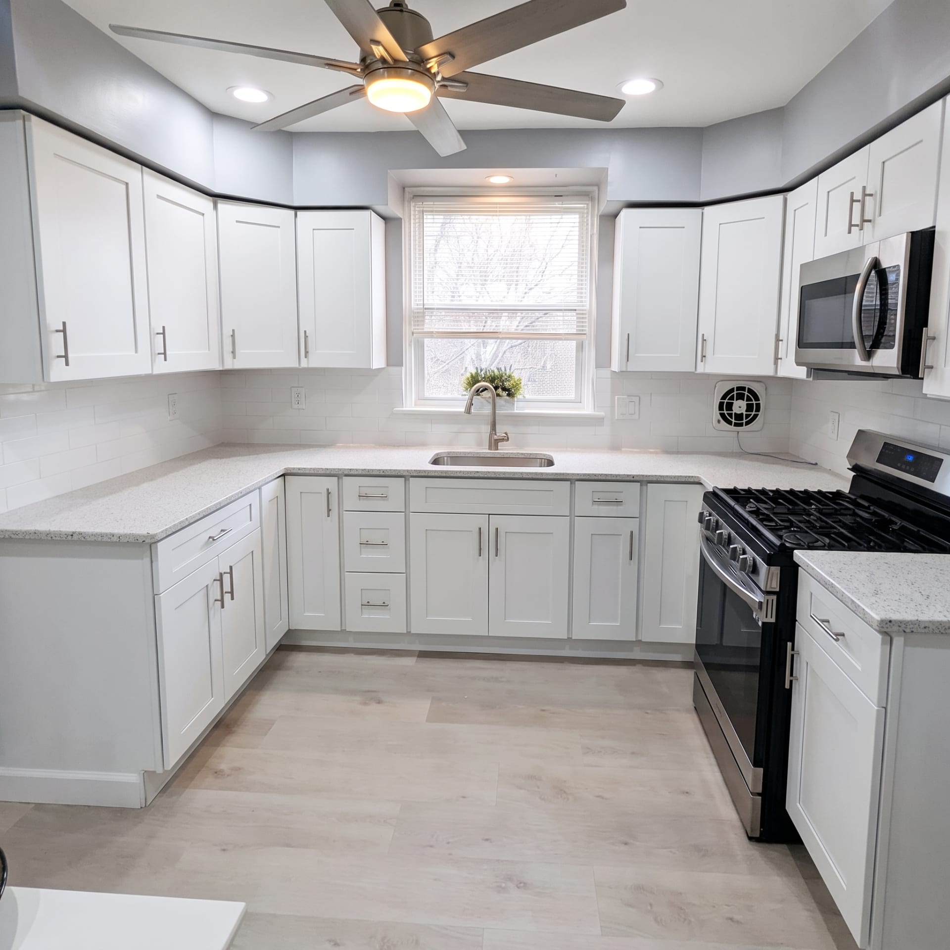 Finished white U-shaped kitchen with ceiling fan, AZ Home Remodeling