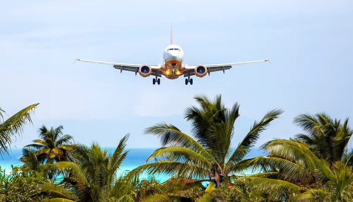 Frontier Airlines aircraft on tarmac with travelers boarding at sunset