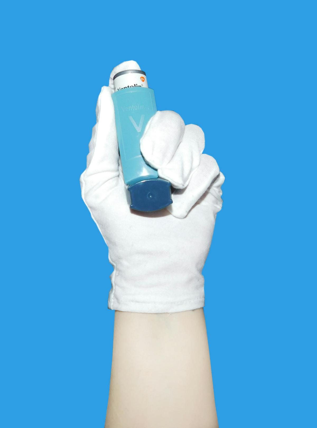 Hand holding asthma inhaler