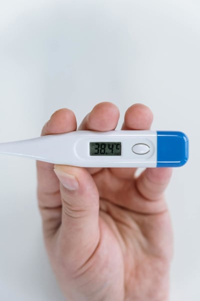Person holding thermometer — fever