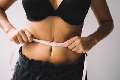 Hands measuring waistline — weight loss
