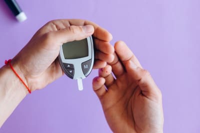 Person holding glucose meter