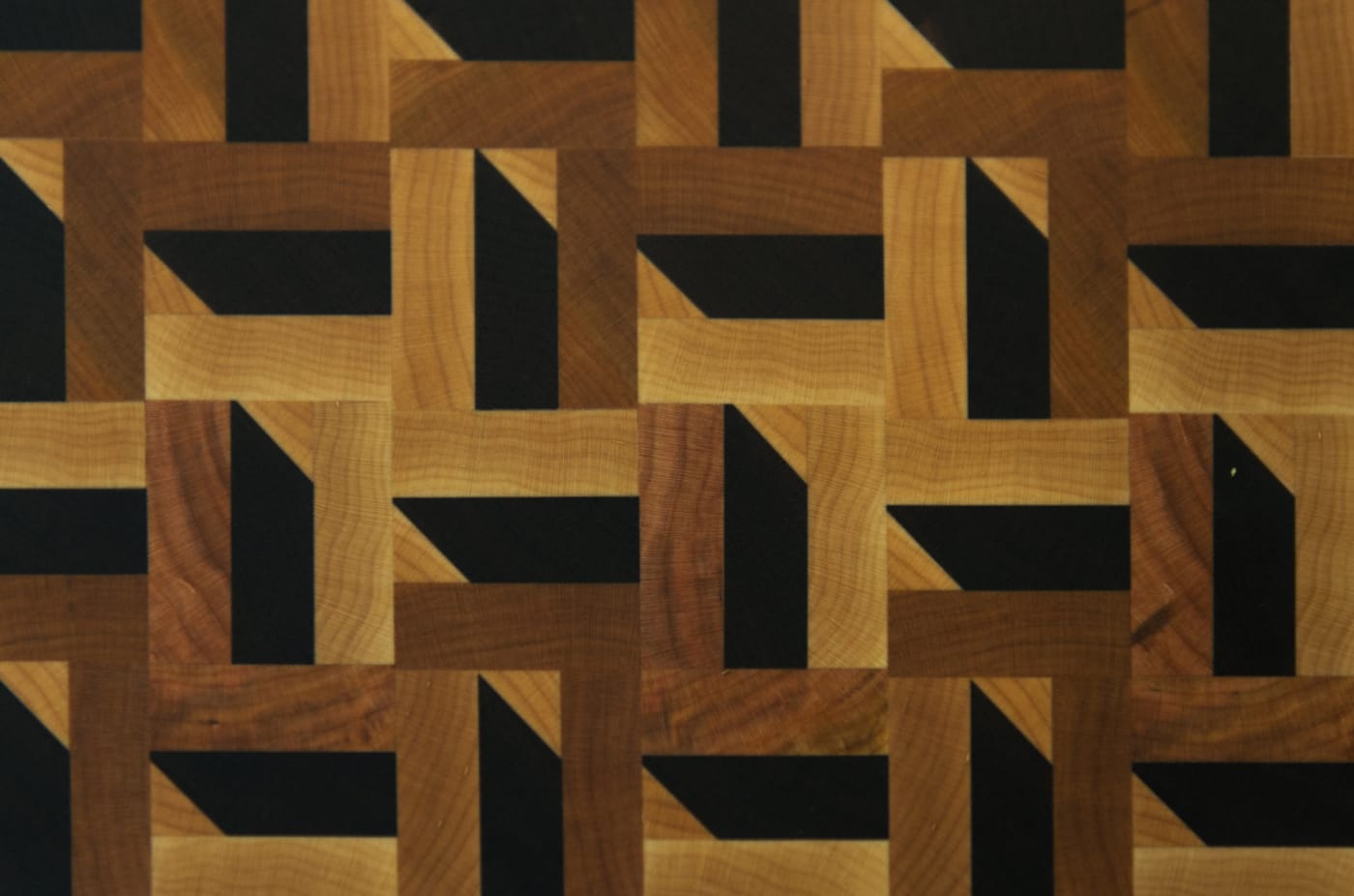 End grain of a cutting board, light and dark woods in an interlocking pattern