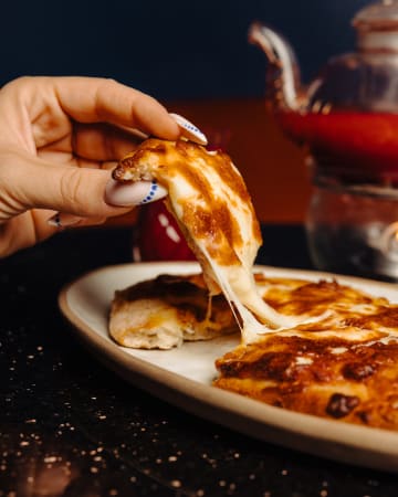 Une part de pizza qui file au fromage