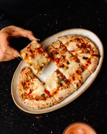 Pizza coupée en parts sur un plat ovale