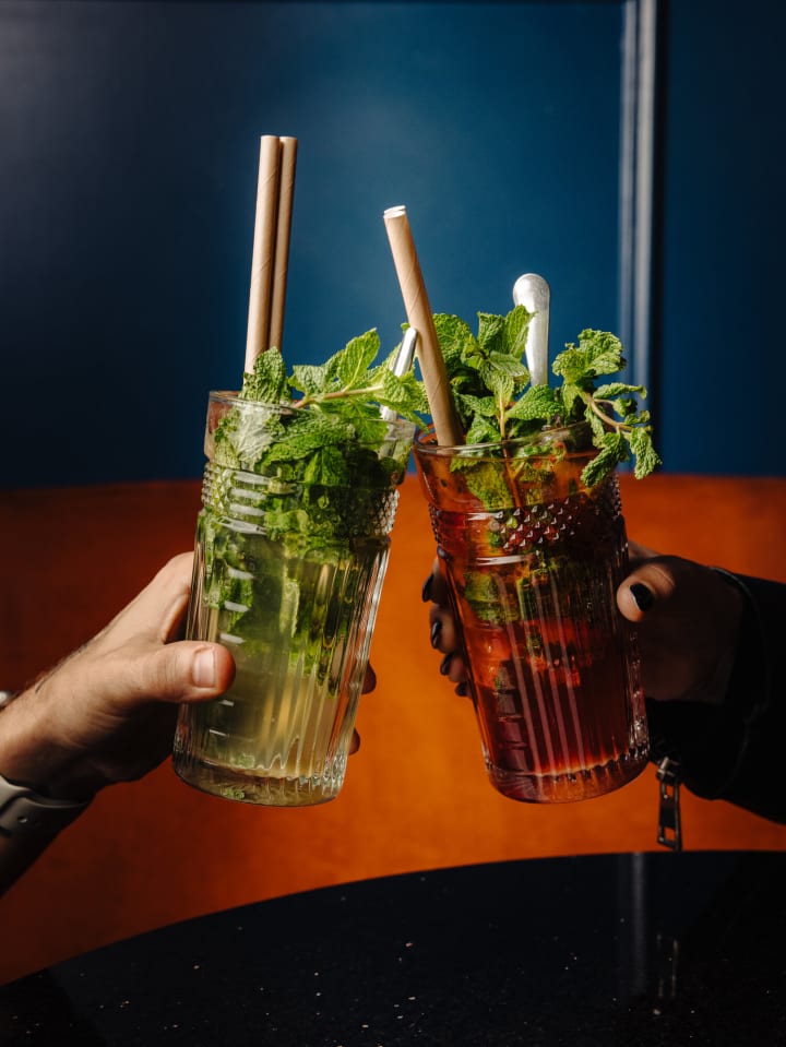 Deux virgin mojitos qui trinquent devant le velours orange