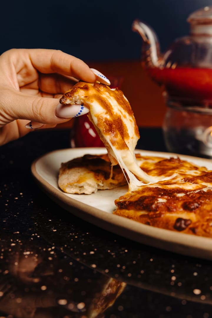 Une part de pizza qui file au fromage