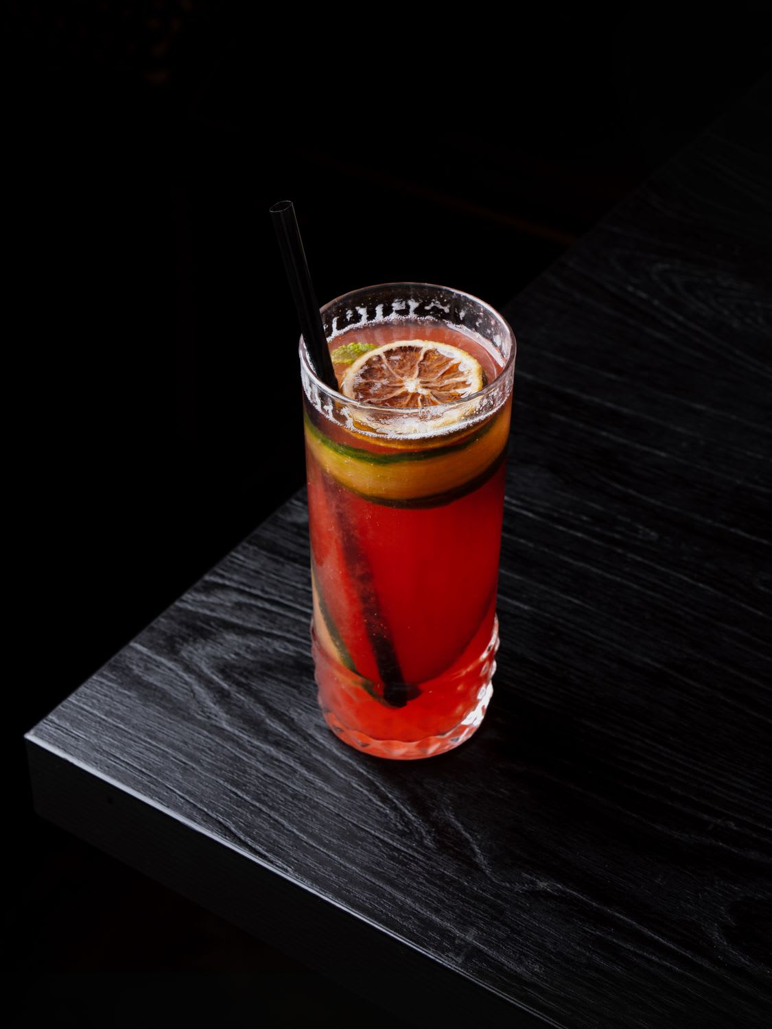 Cocktail tall rouge translucide, fond sombre