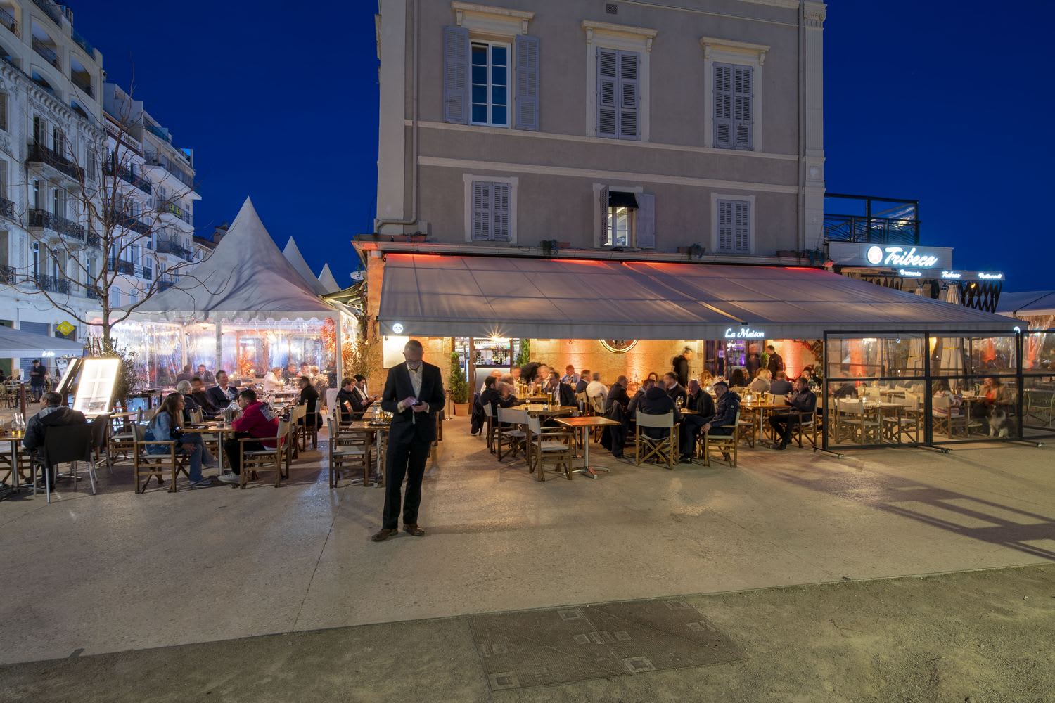 La façade de La Maison illuminée la nuit