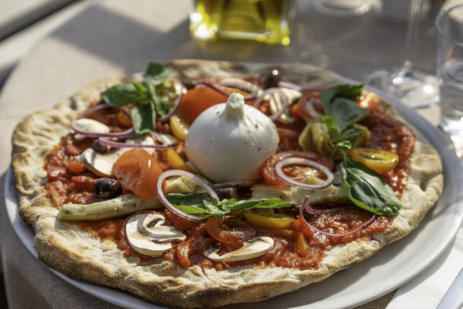Pizza burrata et légumes du soleil en terrasse