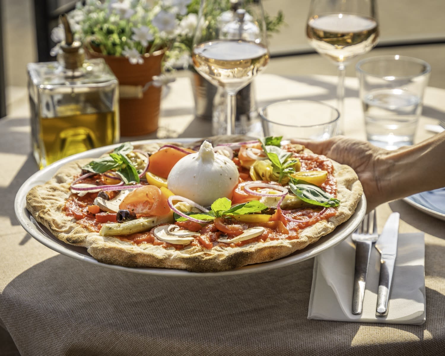 Pizza burrata servie à table, verre de rosé