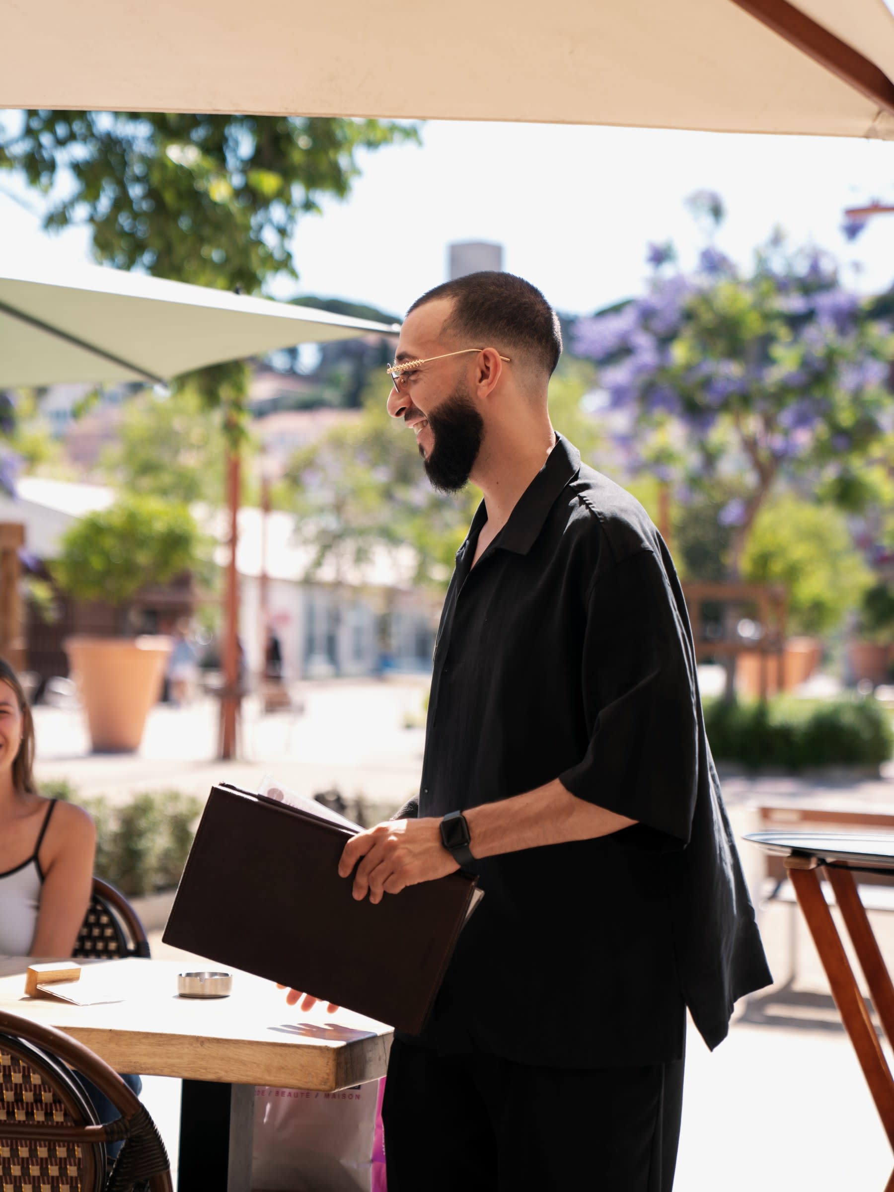 Un serveur souriant avec la carte