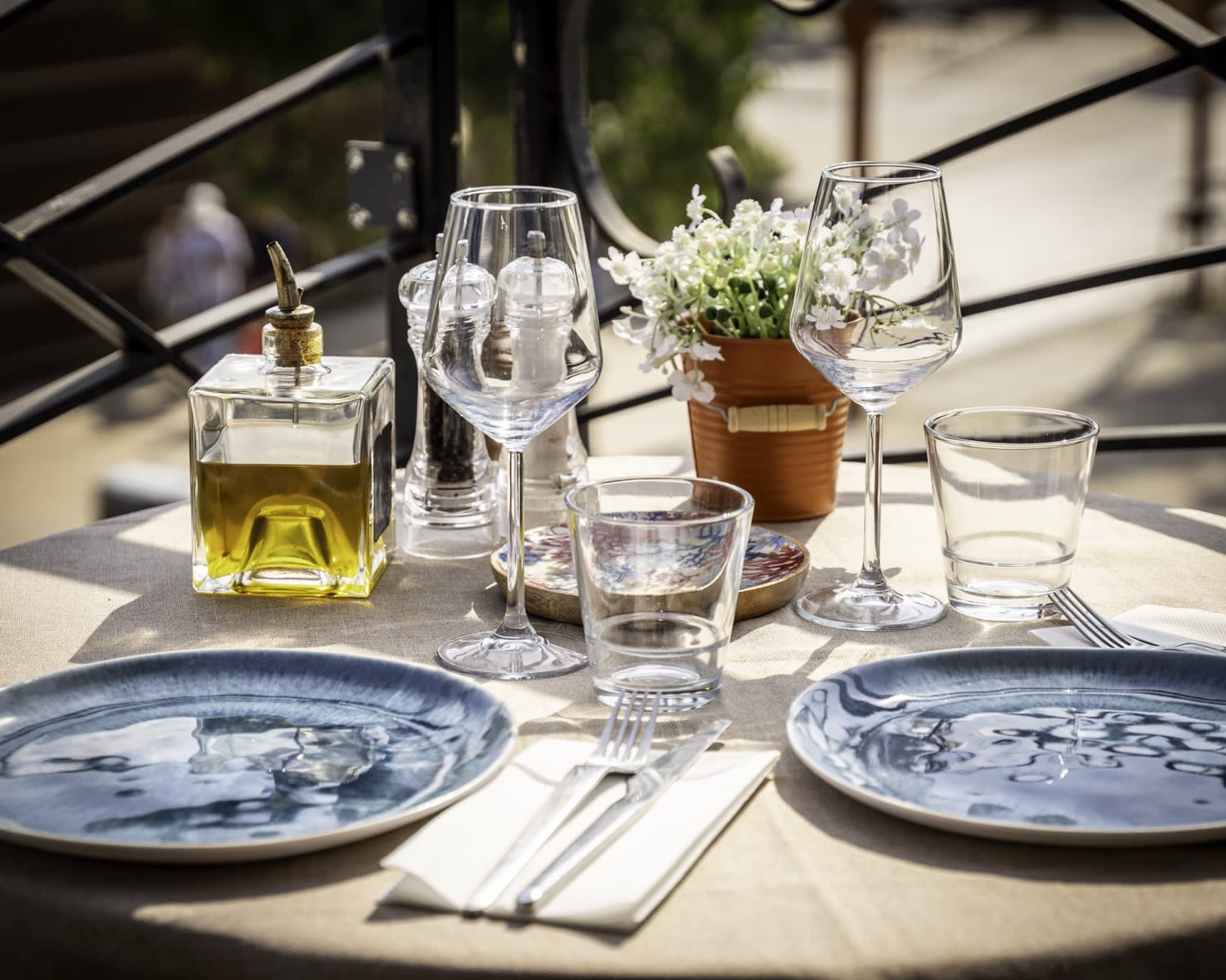 Table dressée en terrasse, céramique bleue et huile d'olive