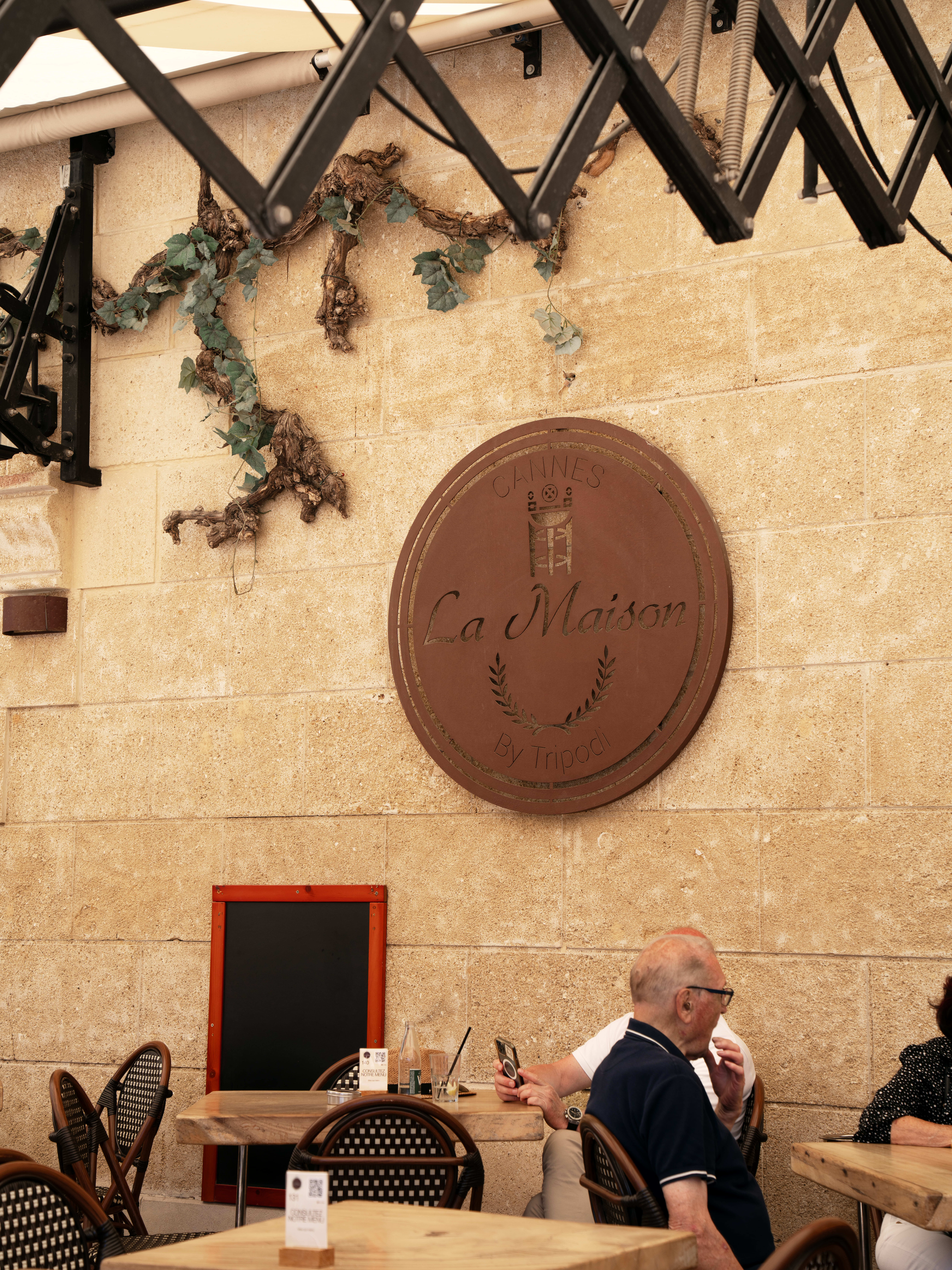 Le médaillon « La Maison by Tripodi » sur le mur de pierre de la terrasse, esplanade Félix Faure
