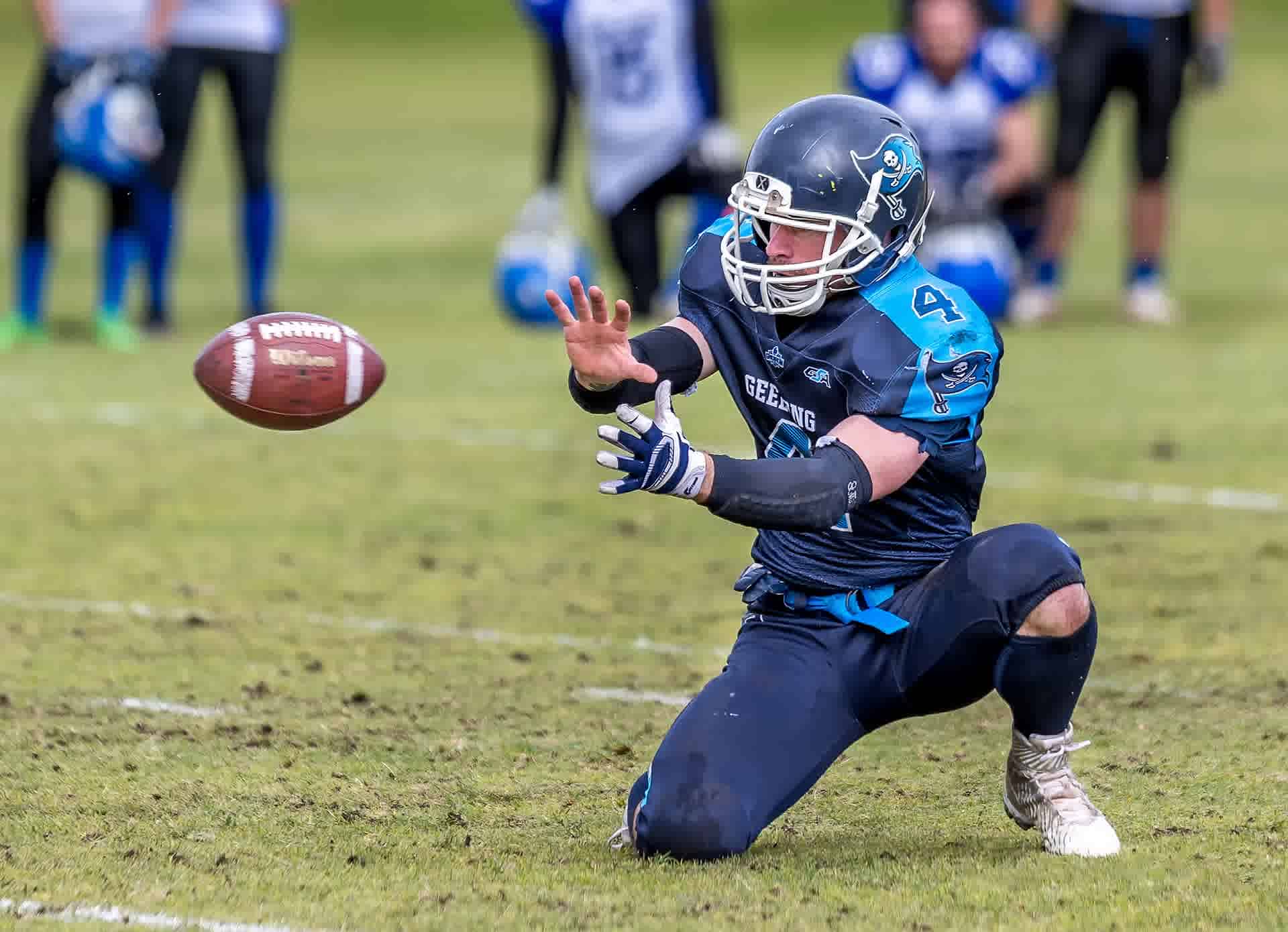 man in blue jersey shirt catching a ball